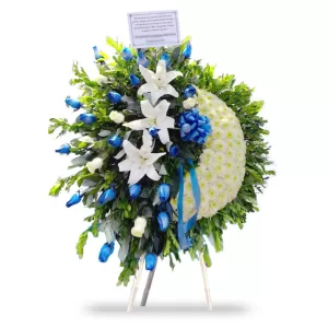 Corona funeral de pompones blancos con rosas azules y lilium