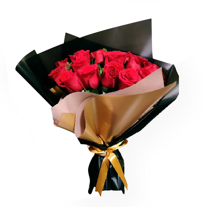 Ramo elaborado con rosas rojas envueltas en papel pergamino