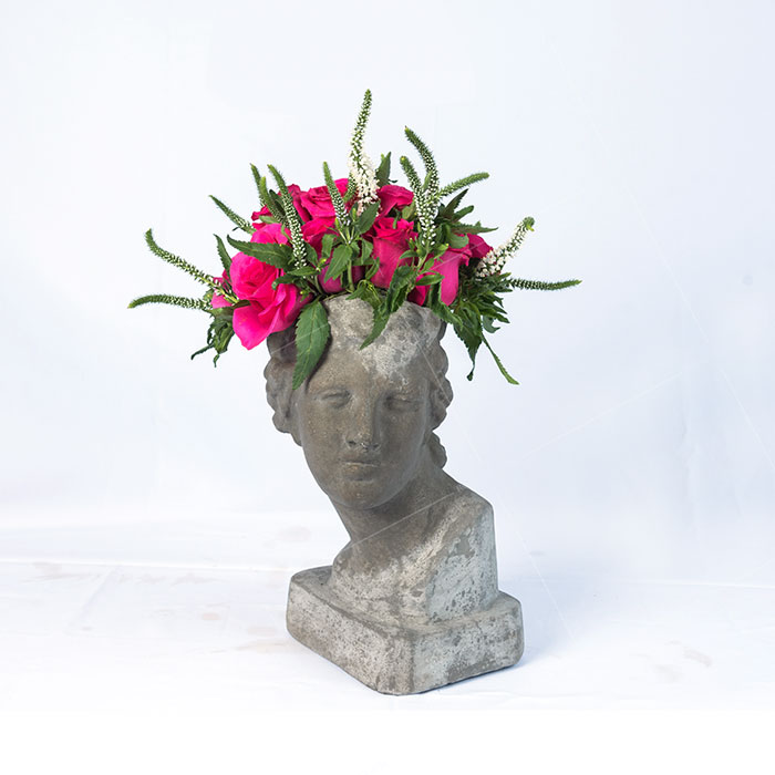 Escultura de cemento afrodita con rosas fucsia