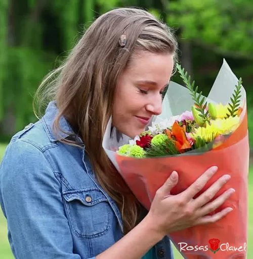 Mujer oliendo las flores.