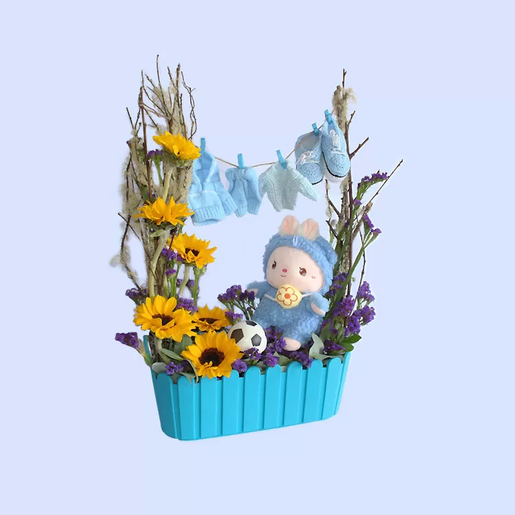 Nacimiento floral con girasoles y peluche.
